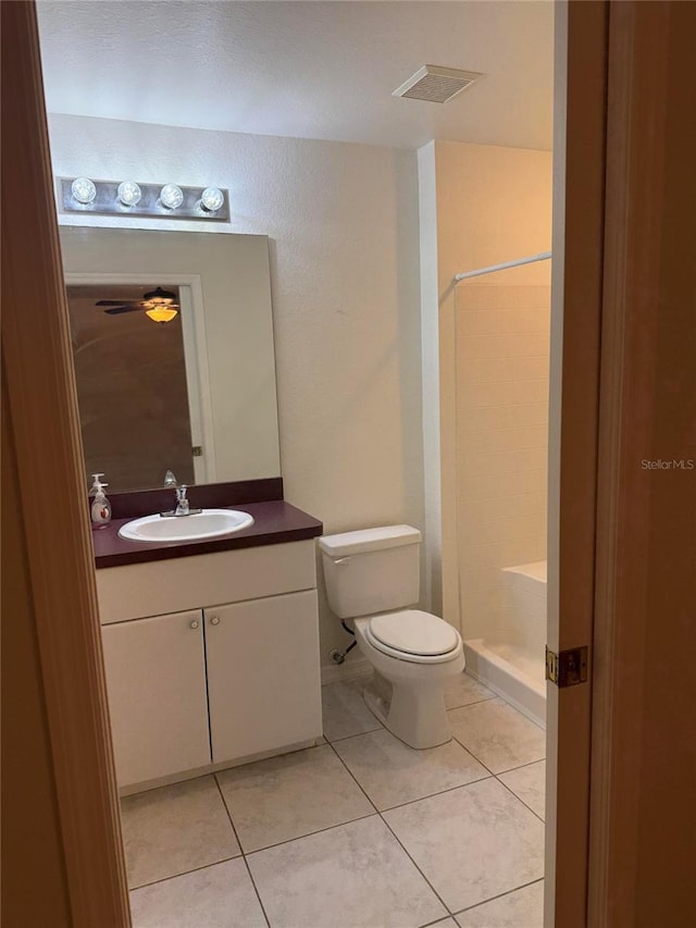 bathroom featuring walk in shower, tile patterned floors, toilet, and vanity