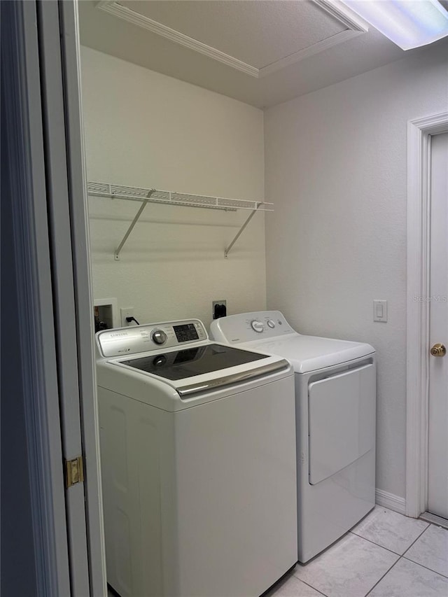 laundry area with separate washer and dryer and light tile patterned floors