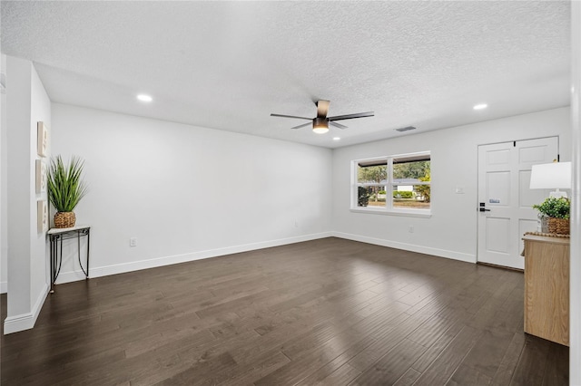 unfurnished living room with ceiling fan, dark wood-type flooring, and a textured ceiling