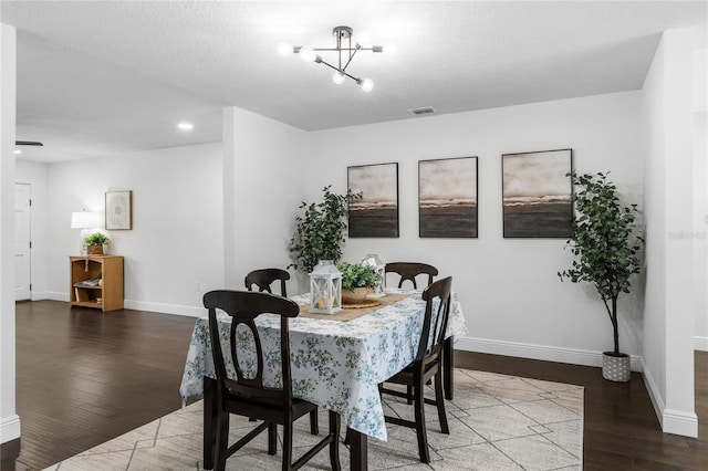 dining space with a notable chandelier and dark wood-type flooring