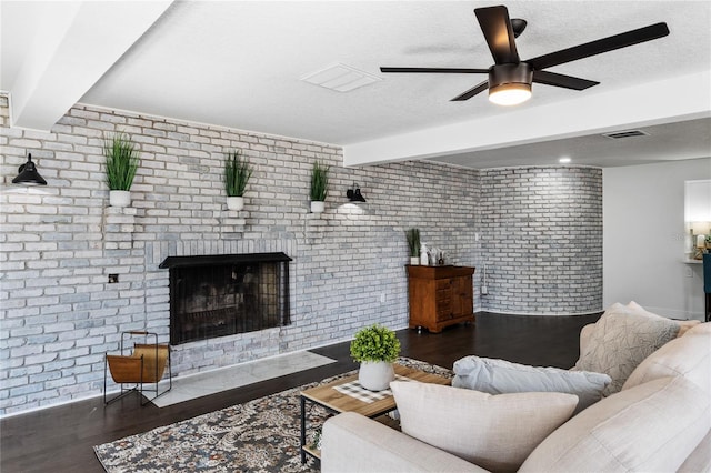 living room with beam ceiling, a fireplace, dark hardwood / wood-style floors, and brick wall