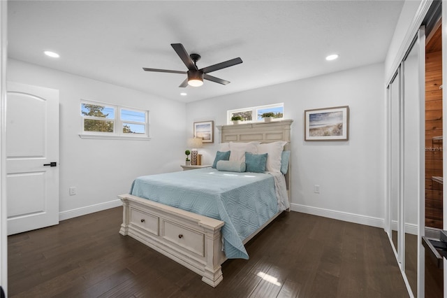 bedroom featuring dark wood-type flooring, ceiling fan, and a closet