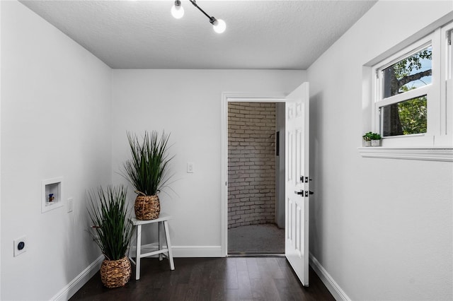 washroom with washer hookup, dark hardwood / wood-style flooring, a textured ceiling, and electric dryer hookup