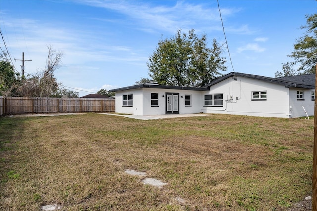 back of property with a yard and a patio area