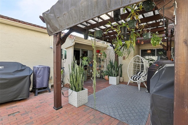 view of patio with area for grilling and a pergola