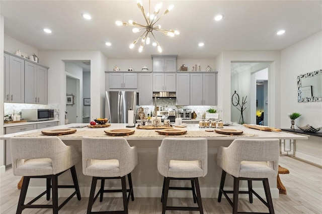 kitchen with a large island, a kitchen breakfast bar, and appliances with stainless steel finishes