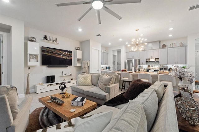 living room with ceiling fan with notable chandelier