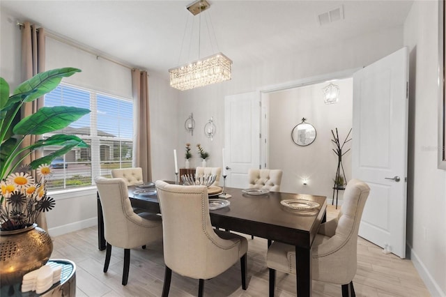 dining area featuring an inviting chandelier and light hardwood / wood-style floors