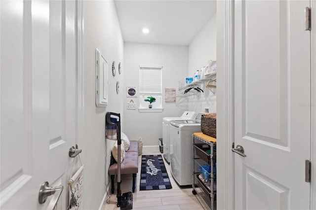 clothes washing area with washing machine and clothes dryer and electric panel