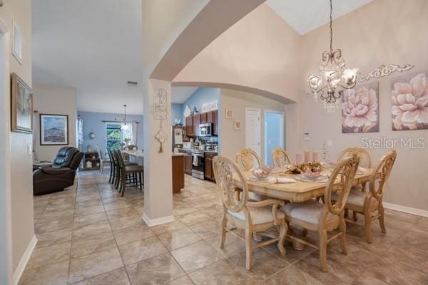 dining space featuring a chandelier and high vaulted ceiling