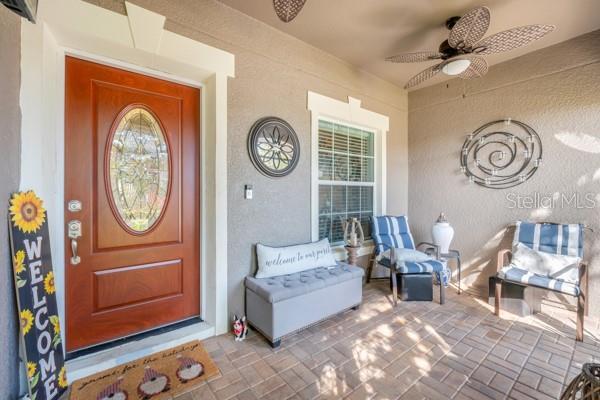 doorway to property with ceiling fan and a porch