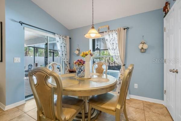 dining area featuring light tile patterned floors, vaulted ceiling, and plenty of natural light