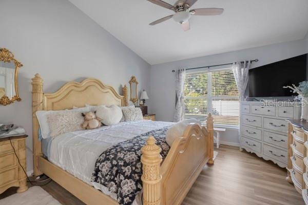 bedroom featuring ceiling fan, lofted ceiling, and light hardwood / wood-style flooring