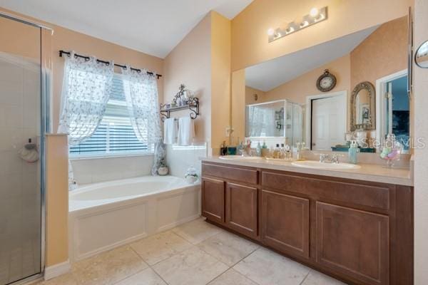 bathroom featuring tile patterned flooring, shower with separate bathtub, lofted ceiling, and vanity