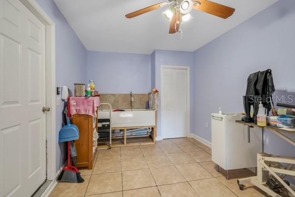 interior space with ceiling fan and light tile patterned flooring