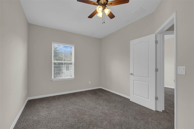 unfurnished room featuring ceiling fan and dark carpet