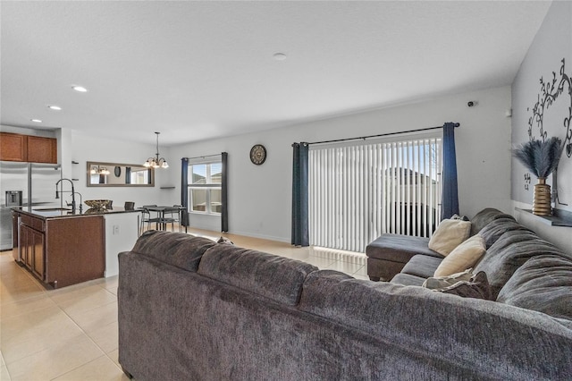 living room with a chandelier, sink, and light tile patterned floors