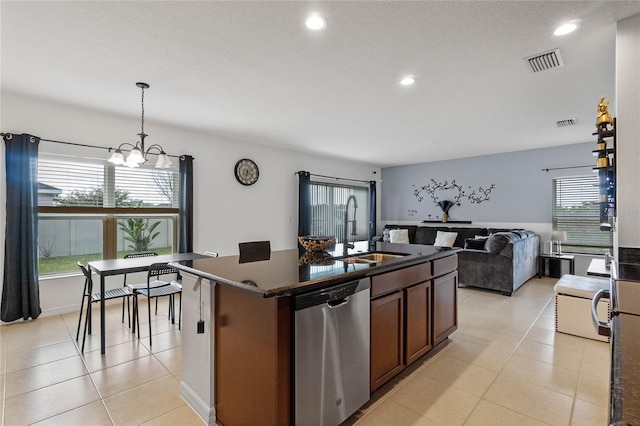 kitchen featuring sink, stainless steel dishwasher, plenty of natural light, pendant lighting, and a kitchen island with sink