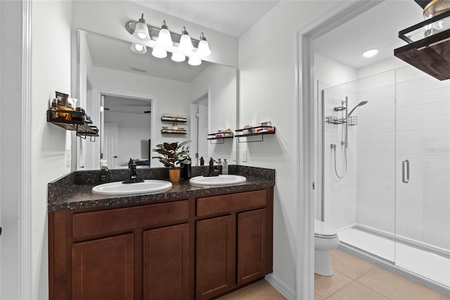 bathroom with vanity, a shower with shower door, tile patterned floors, and toilet