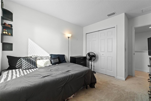 carpeted bedroom with a closet and a textured ceiling