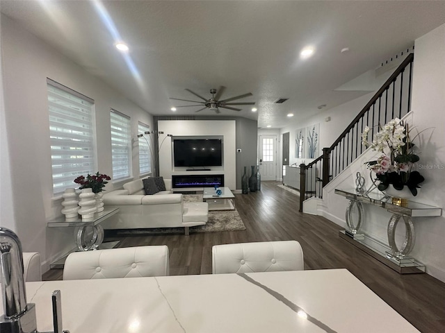 living room featuring ceiling fan, dark hardwood / wood-style flooring, and a textured ceiling