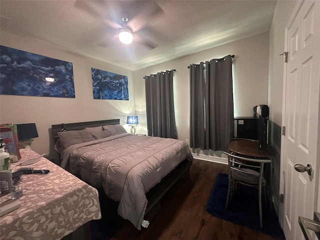 bedroom featuring dark wood-type flooring, ceiling fan, and a textured ceiling