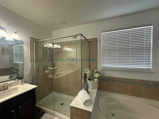 bathroom featuring vanity, shower with separate bathtub, and a textured ceiling