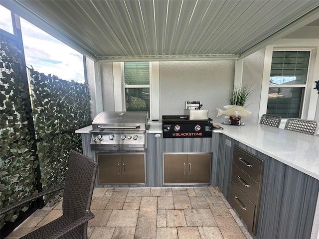 view of patio featuring an outdoor kitchen and a grill