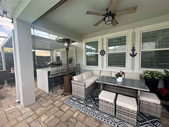 view of patio featuring french doors, a bar, ceiling fan, an outdoor hangout area, and exterior kitchen