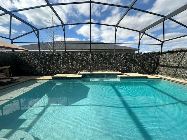 view of swimming pool featuring a lanai