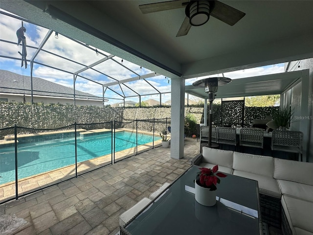 view of pool featuring ceiling fan, outdoor lounge area, glass enclosure, and a patio area