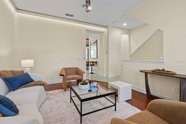 living room with light hardwood / wood-style floors and rail lighting