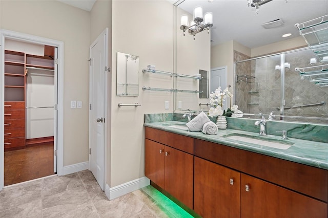 bathroom with vanity, a shower with door, and an inviting chandelier