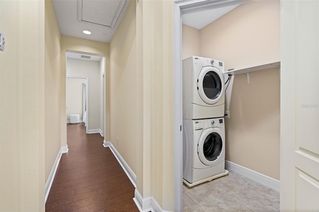 washroom with stacked washer and clothes dryer and light hardwood / wood-style floors