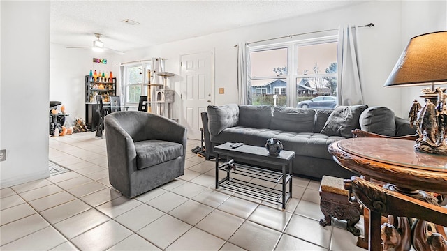 tiled living room featuring ceiling fan and a textured ceiling