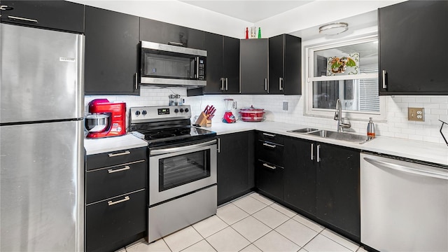 kitchen featuring stainless steel appliances, sink, decorative backsplash, and light tile patterned floors