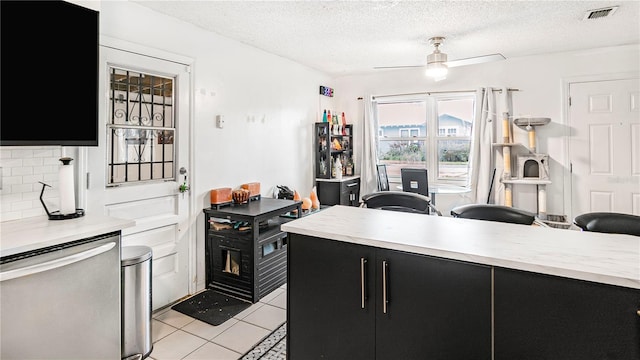 kitchen featuring dishwasher, backsplash, light tile patterned floors, ceiling fan, and a textured ceiling