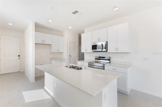 kitchen featuring stainless steel appliances, white cabinetry, sink, and a center island with sink