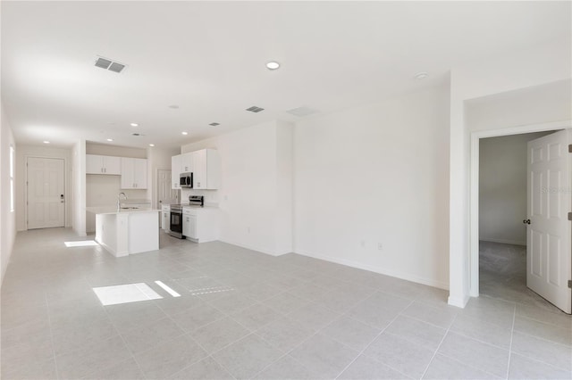 unfurnished living room featuring sink and light tile patterned floors