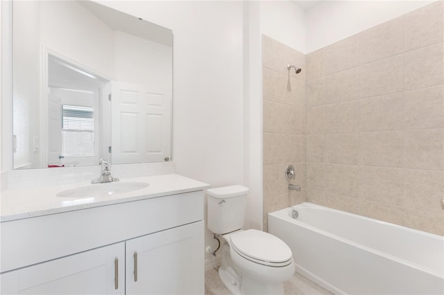 full bathroom featuring tiled shower / bath, vanity, and toilet