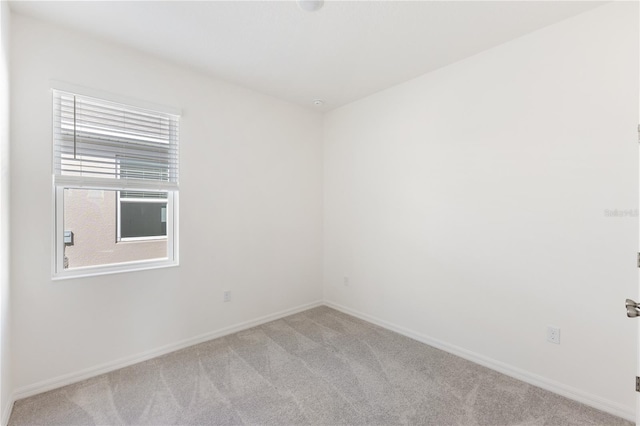 spare room featuring light colored carpet