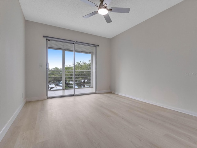 spare room with ceiling fan, light hardwood / wood-style floors, and a textured ceiling