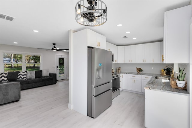 kitchen featuring appliances with stainless steel finishes, sink, white cabinets, ceiling fan, and light wood-type flooring