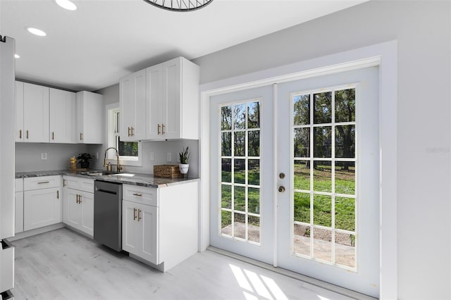 kitchen with sink, black dishwasher, white cabinets, french doors, and dark stone counters