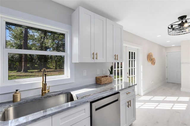 kitchen with dishwasher, sink, white cabinets, and light stone counters