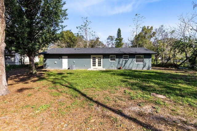 rear view of property with french doors, central AC, and a lawn