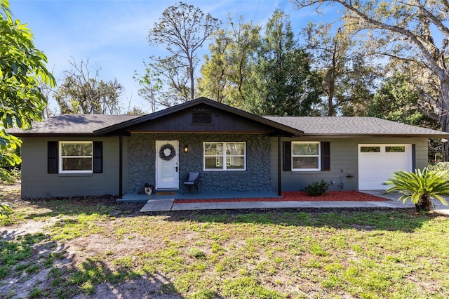 single story home featuring a garage, a front yard, and covered porch