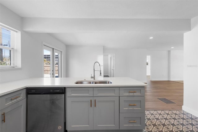 kitchen with stainless steel dishwasher, dark hardwood / wood-style flooring, gray cabinets, and sink