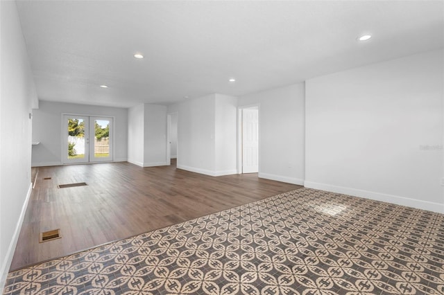 unfurnished living room featuring dark hardwood / wood-style floors and french doors