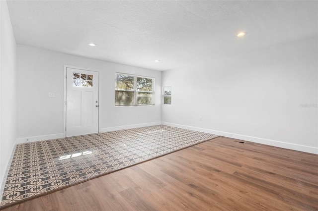 foyer with hardwood / wood-style flooring and a textured ceiling